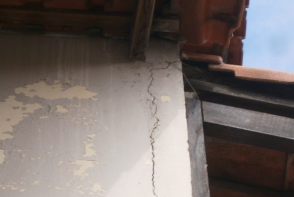 Vista da rachadura irregular entre o pilar em concreto armado e a parede de alvenaria na fachada lateral, cuja patologia surgiu, devido a ausência de entelamento, mais precisamente na interface “alvenaria + estrutura”.